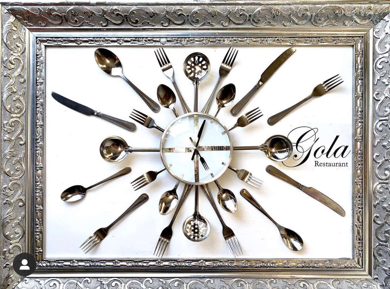 A clock made from cutlery inside an ornate silver frame