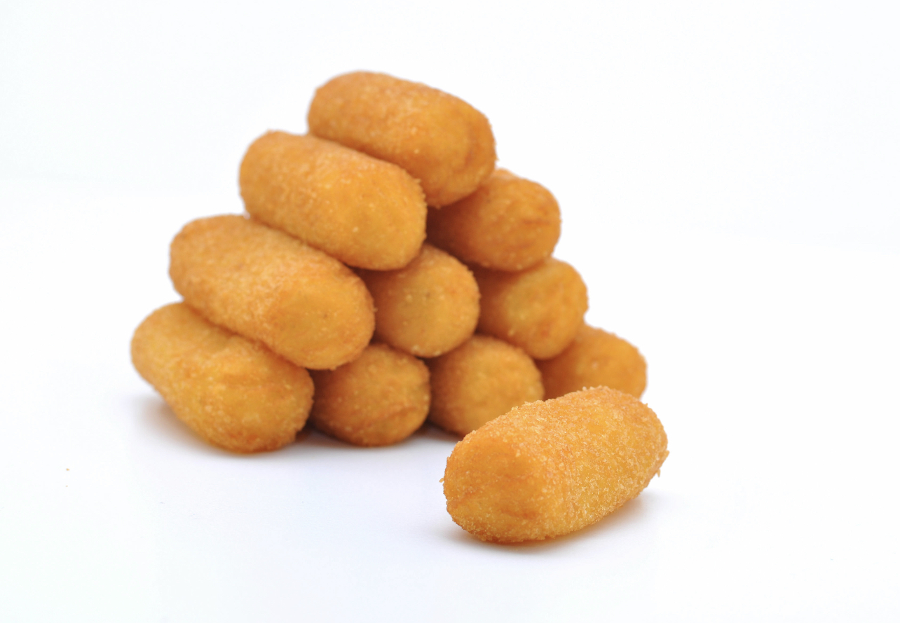 A stack of golden breaded croquettes on a white background