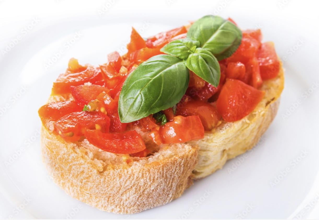 Toasted bread topped with chopped tomatoes and fresh basil