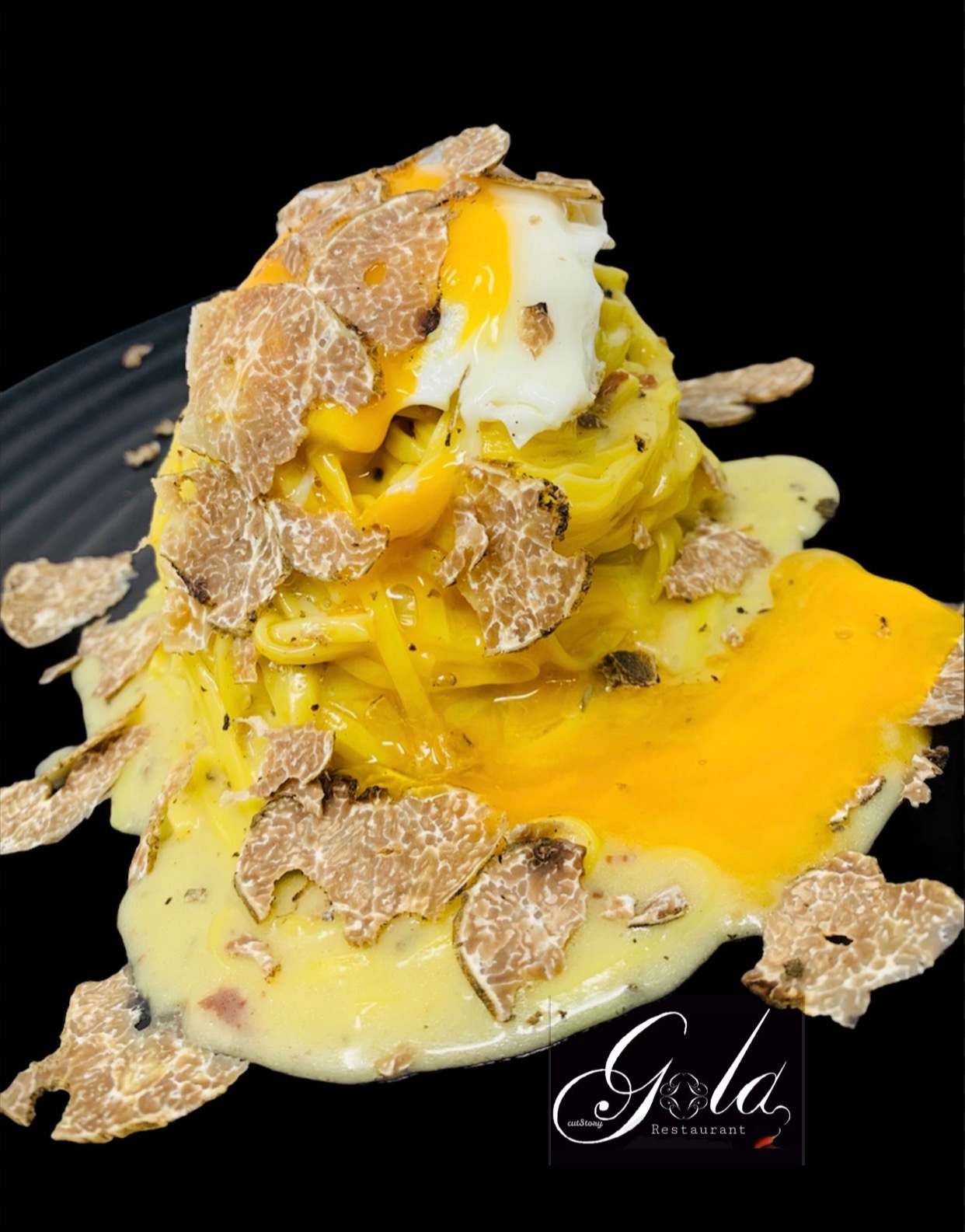 Ribbon pasta topped with an egg and truffle shavings against a dark background